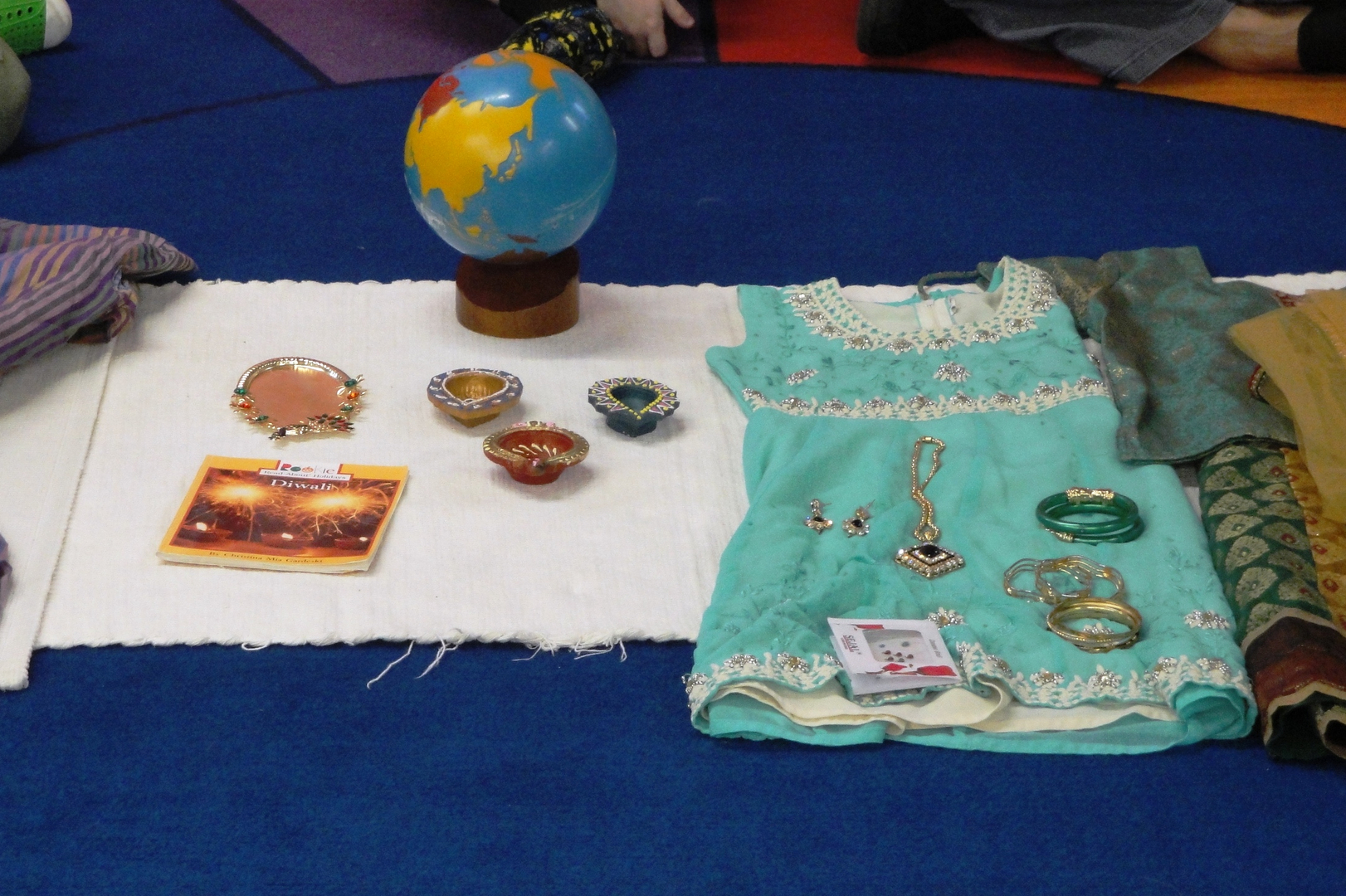 Diwali cultural celebration display — globe, traditional dress, and diyas